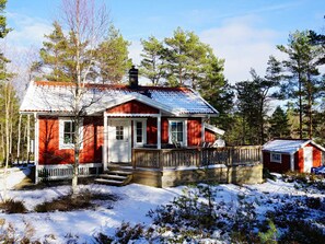 A red wooden cabin with a porch, surrounded by trees and snow. - 4 Star Holiday Home in Bullaren (Bullaren)