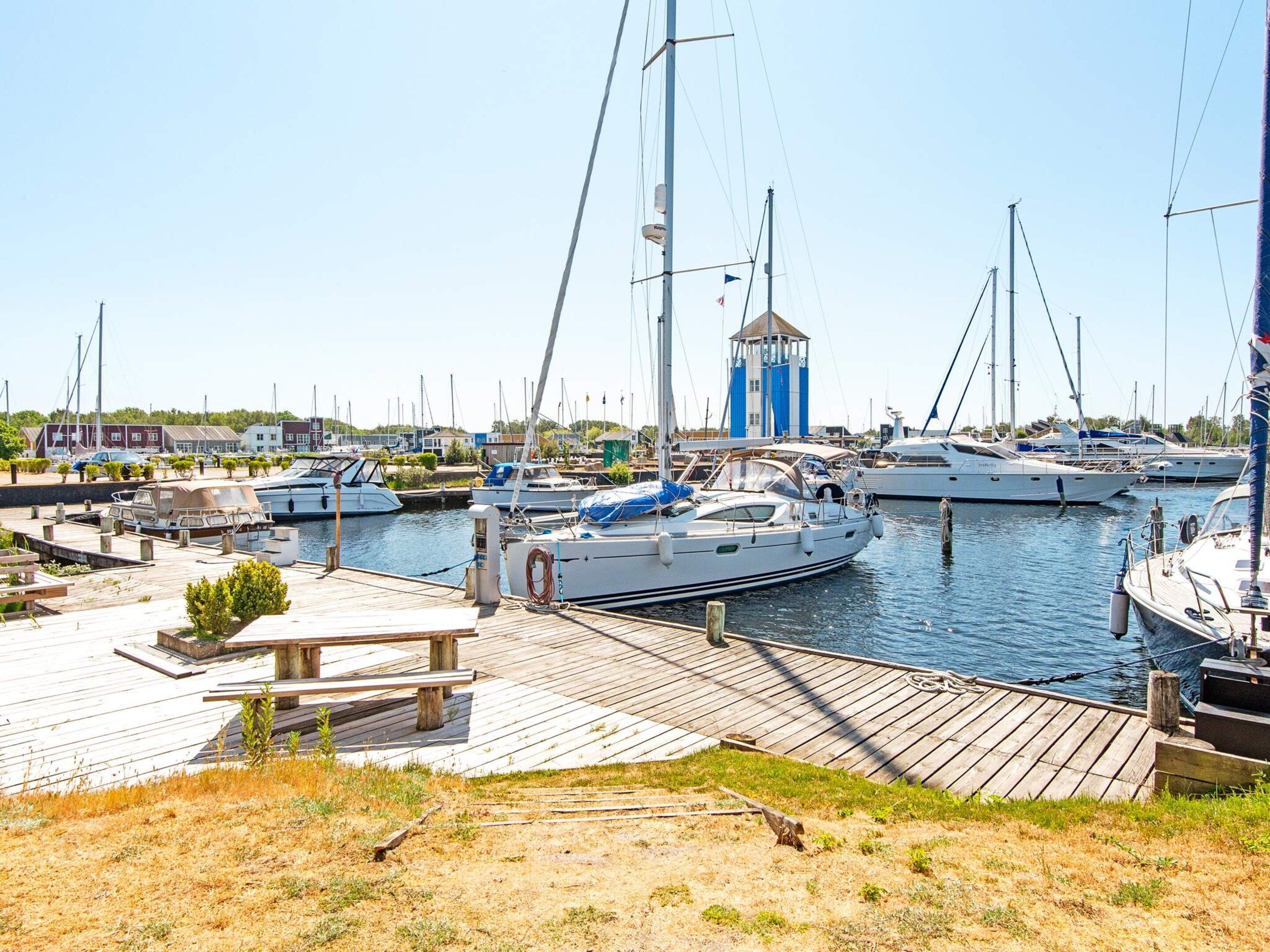 Un port de plaisance avec des bateaux amarrés, une jetée en bois et une petite structure en forme de tour.