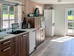Una cocina moderna con armarios de madera, un refrigerador blanco y una cafetera.