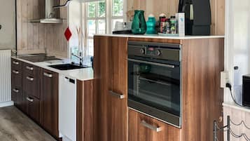 A modern kitchen with wooden cabinets, a stainless steel oven, and a dishwasher.