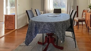 A dining area with a round table, chairs, a wooden sideboard, and a view through a window. - 12 Person Holiday Home in Nosund-by Traum (Nosund)
