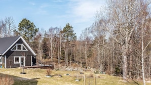 A modern house with a deck, surrounded by a forested area. - 12 Person Holiday Home in Nosund-by Traum (Nosund)