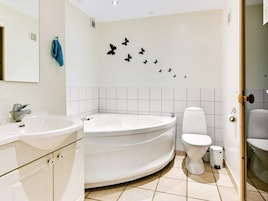 A bathroom with a bathtub, a toilet, and a sink.