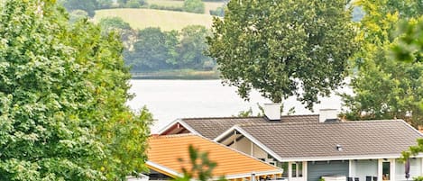 A residential area with houses, a lawn, and a body of water in the background.