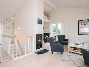 A modern living room with a fireplace, seating area, and a staircase leading to an upper level. - 6 Person Holiday Home in Aabenraa (Aabenraa)