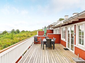 A wooden deck with a table and chairs, overlooking a natural landscape. - 6 Person Holiday Home in Aabenraa (Aabenraa)