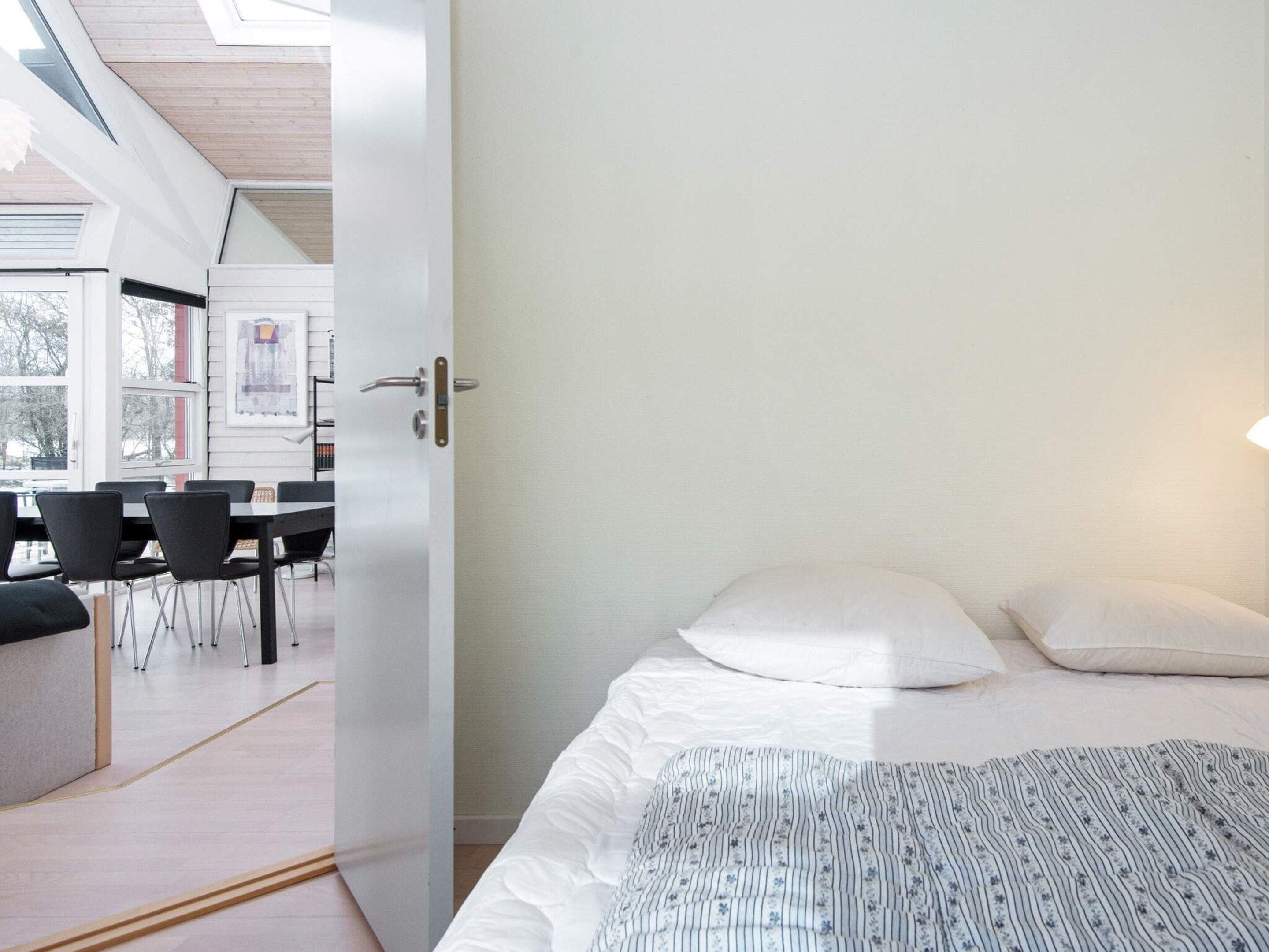 A room with a bed, a desk, and chairs.