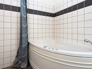 A bathroom with a bathtub, tiled walls, and a patterned shower curtain. - 6 Person Holiday Home in Vemb-by Traum (Vemb)