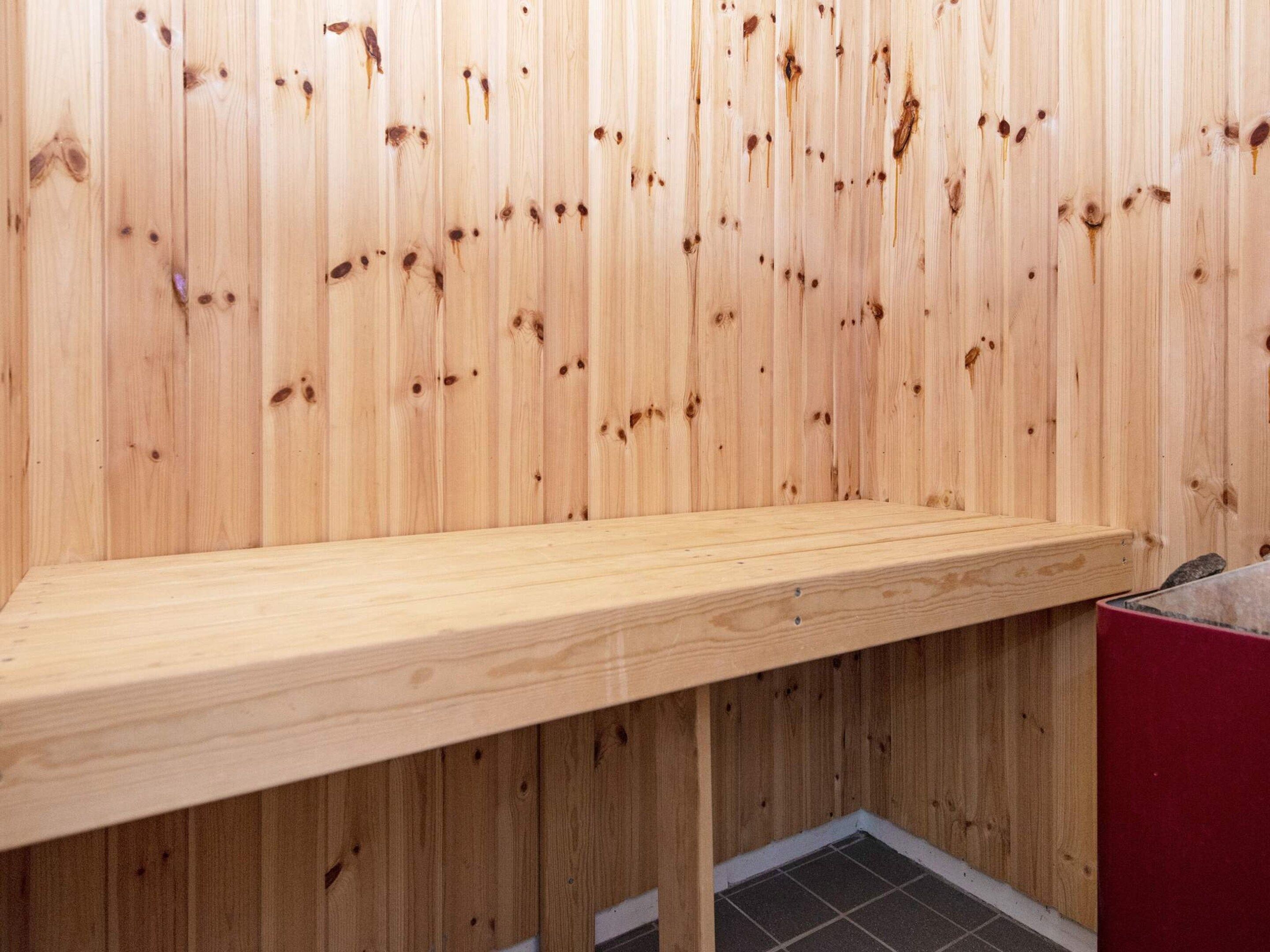 Un banco de madera en una habitación con paneles de madera verticales.