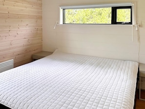 A single bed with a quilted mattress in a room with wooden walls and a window. - 7 Person Holiday Home in Jerup-by Traum (Jerup)