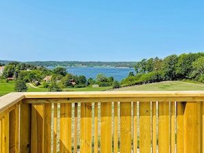 A wooden deck overlooking a lake with a clear sky. - 5 Star Holiday Home in Uddevalla (Uddevalla)