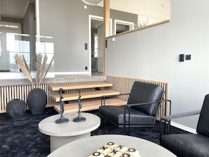 A modern interior with a seating area, a round table, and a staircase. - 5 Star Holiday Home in Uddevalla (Uddevalla)