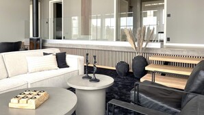A modern living room with a sofa, coffee table, and a fireplace. - 5 Star Holiday Home in Uddevalla (Uddevalla)