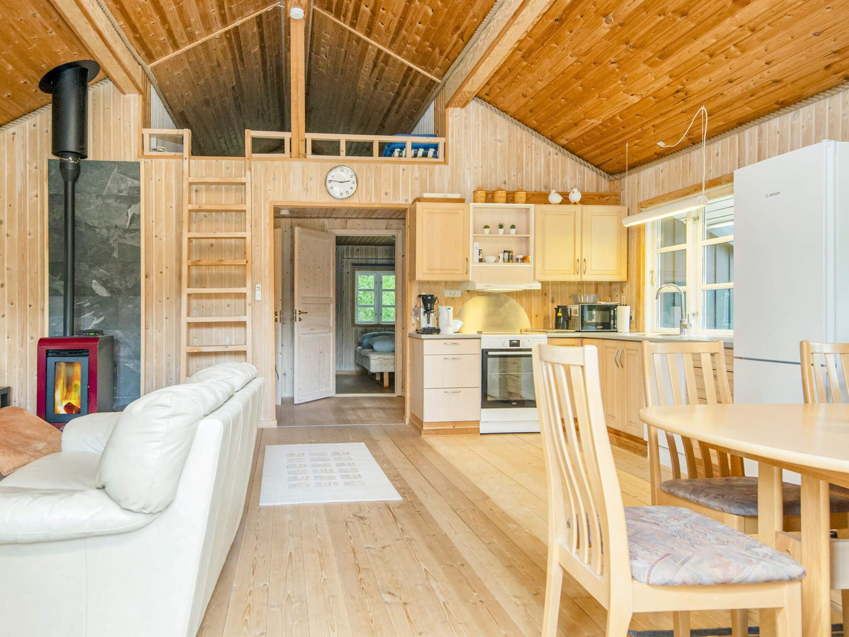 A cozy cabin interior with a living area, a kitchen, and a dining space.