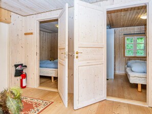 A wooden interior with a bed, a window with a view, and a fire extinguisher. - Lush Home in Glesborg, 6 Guests (Glesborg)