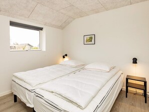 A bedroom with a bed, a window, a wall-mounted picture, and a bedside table. - 10 Person Holiday Home in Idestrup (Idestrup)