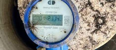 A digital water meter with a blue casing, displaying a reading of 000-42174.