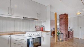 Eine moderne Küche mit weißen Schränken, einer Holz Arbeitsplatte und einem eingebauten Ofen.