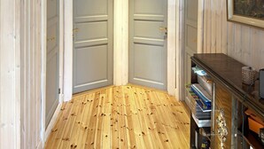 Ein Eckzimmer mit zwei Türen, Holzboden und einem Schreibtisch mit Schubladen.