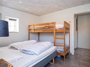 A bunk bed room with a window, a door, and a flat bed with pillows. - 8 Person Holiday Home in Odder (Odder)