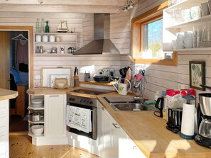 A compact kitchen with a central island, built-in oven, and stainless steel sink.