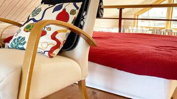Una habitación con una cama, una silla y un ventanal.