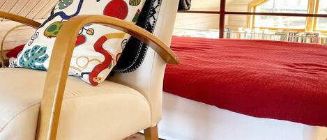 A room with a bed, a chair, and a window.