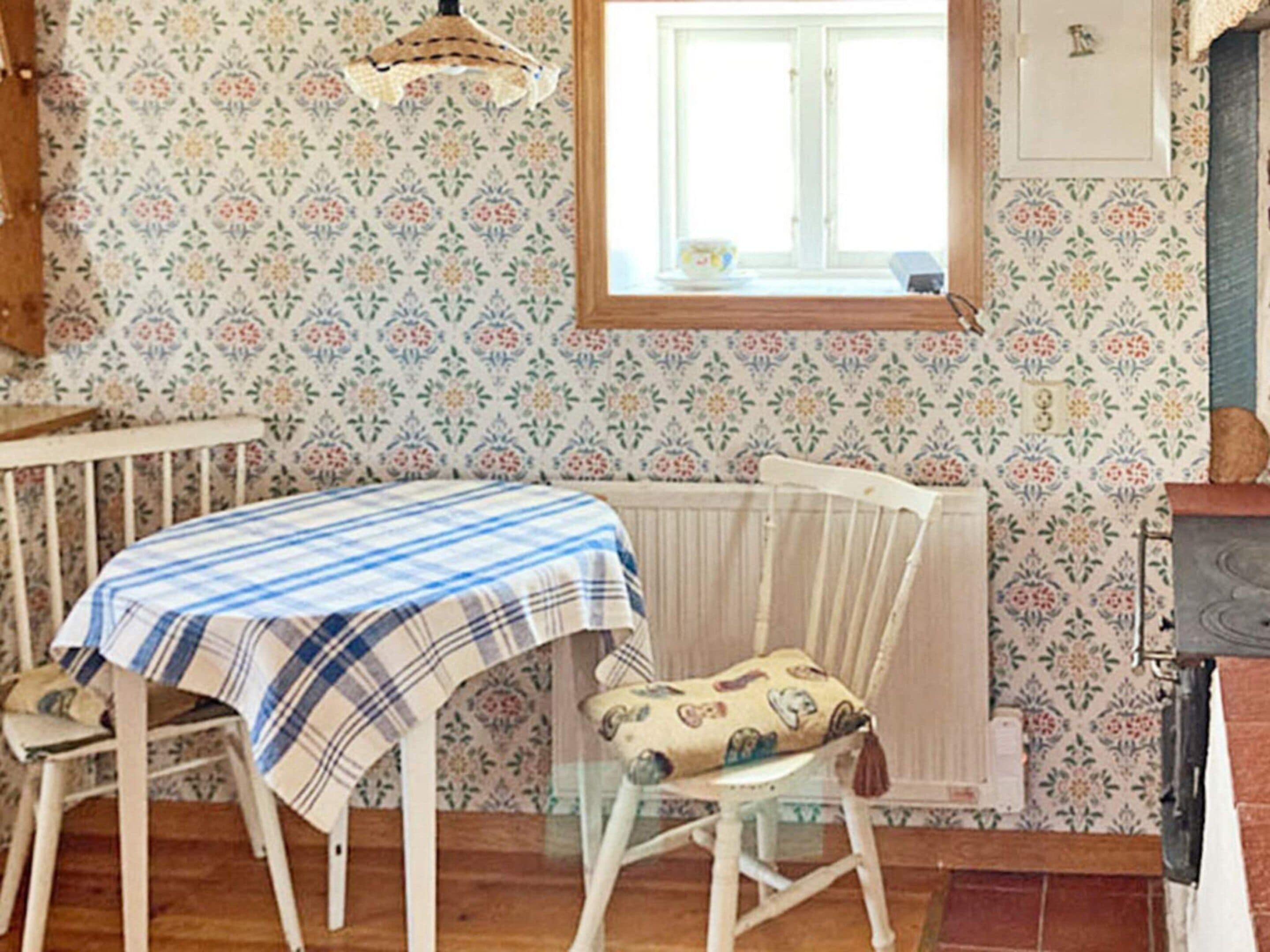 A room with a table and chairs, a radiator, a window, and a cabinet.