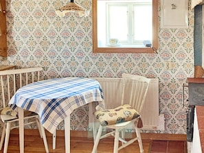A room with a table and chairs, a radiator, a window, and a cabinet. - 5 Person Holiday Home in Bodafors (Bodafors)