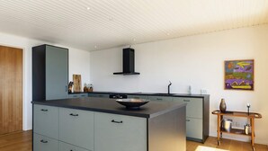 A modern kitchen with a central island, built-in appliances, and a minimalist design. - 10 Person Holiday Home in Assens (Assens)