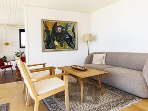 A living room with a sofa, chairs, a coffee table, a painting, and a lamp. - 10 Person Holiday Home in Assens (Assens)
