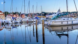 A marina with various boats docked, surrounded by buildings and a clear sky. - Seaside Bliss in Sandkas - By Traum Ferienwohnungen (Allinge)