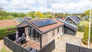 A modern house with solar panels, a deck, and a flag. - 4 Person Holiday Home in Hemmet (Hemmet)