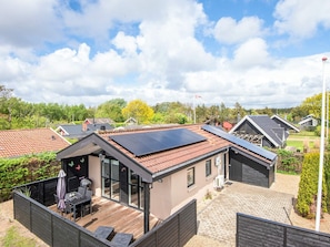 A modern house with solar panels, a deck, and a flag. - 4 Person Holiday Home in Hemmet (Hemmet)