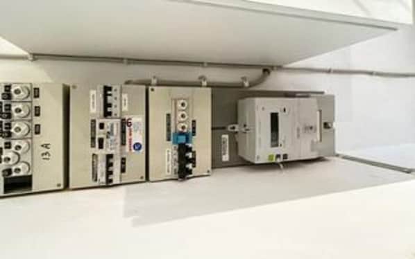 A control panel with various meters and switches, likely for monitoring electrical systems.