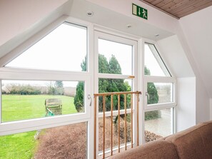 A room with a large skylight, a view of a green field, and a wooden bench outside. - 16 Person Holiday Home in Haderslev (Haderslev)