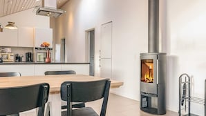 A modern kitchen with a central island, a built-in stove, and a dining area with chairs. - 8 Person Holiday Home in Hals-by Traum (Hals)