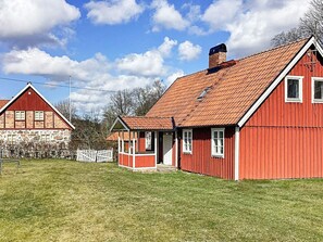 A red barn with a sloped roof and a small porch.