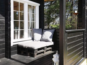 Eine Holzterrasse mit einer Bank und einer Laterne.