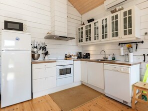 A kitchen with white cabinetry, a built-in oven, a microwave, and a dishwasher. - 7 Person Holiday Home in Logstor (Logstor)