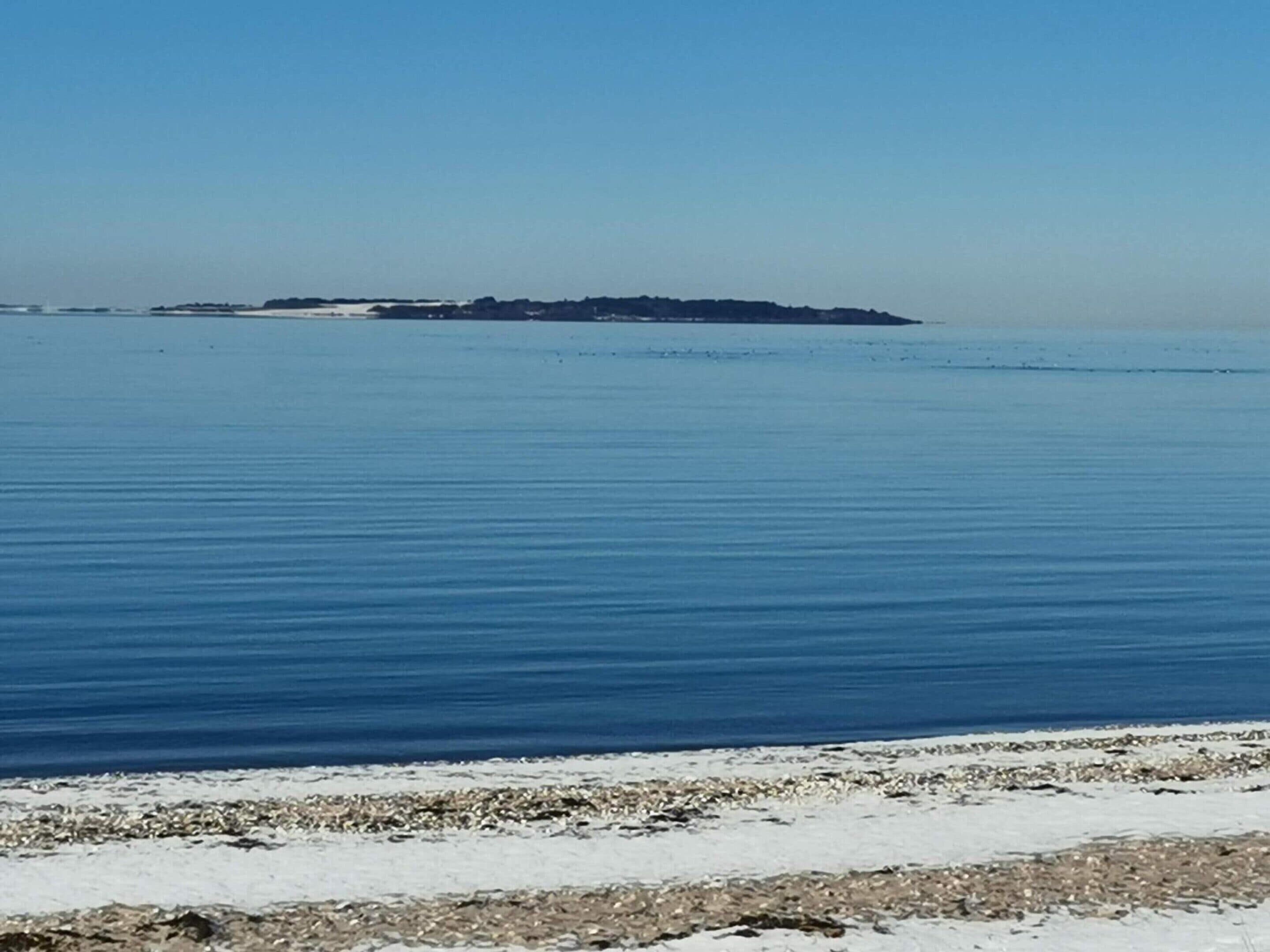 A calm sea with a distant island.
