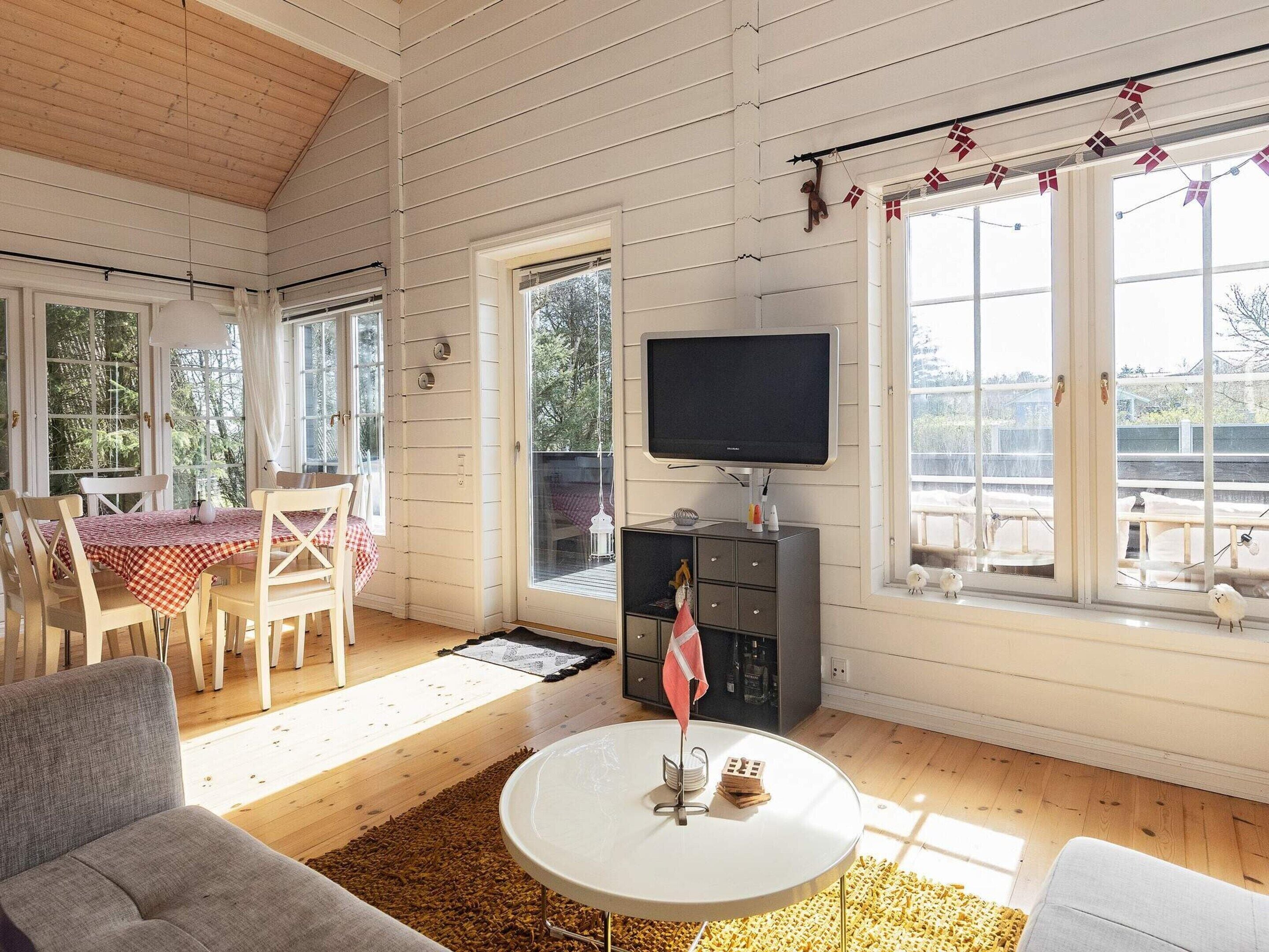 Een gezellige woonkamer met een eethoek, een flatscreen-tv en uitzicht op het landschap.