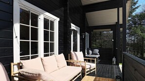 A wooden deck with a sofa, chairs, and a table. - 7 Person Holiday Home in Logstor (Logstor)