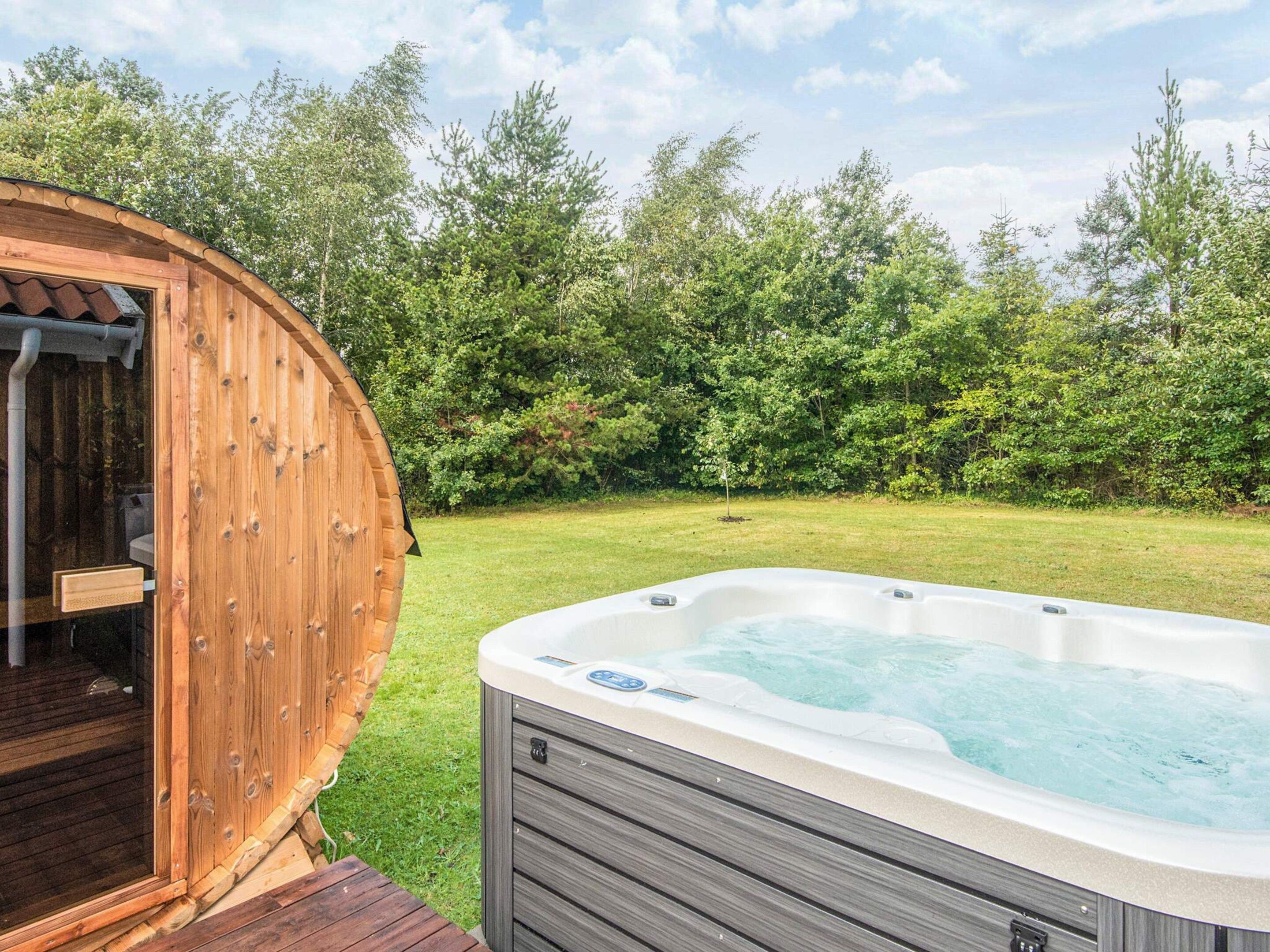 A hot tub in a backyard with a wooden deck and a wooden structure.