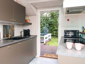 A modern kitchen with a sink, coffee maker, and microwave.