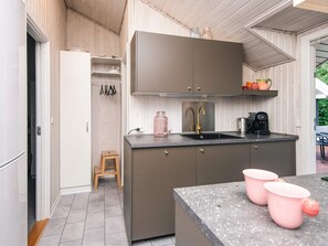 A compact kitchen with a grey countertop, a stainless steel sink, and a coffee maker. - 4 Person Holiday Home in Oksbol (Oksbol)