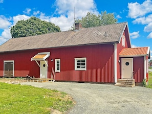A red building with a tiled roof, a door, and a window. - 4 Person Holiday Home in Aneby (Aneby)