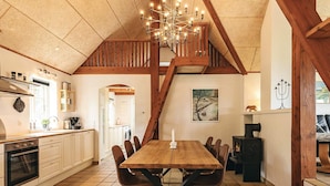 Una cocina amplia con comedor, una escalera y una chimenea.