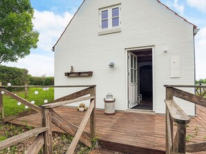A white building with a wooden deck, a door, and a small window. - 6 Person Holiday Home in Nykobing M (Nykobing Mors)