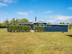 A residential property with a two-story house, a fenced yard, and a clear sky. - 6 Person Holiday Home in Hemmet (Hemmet)